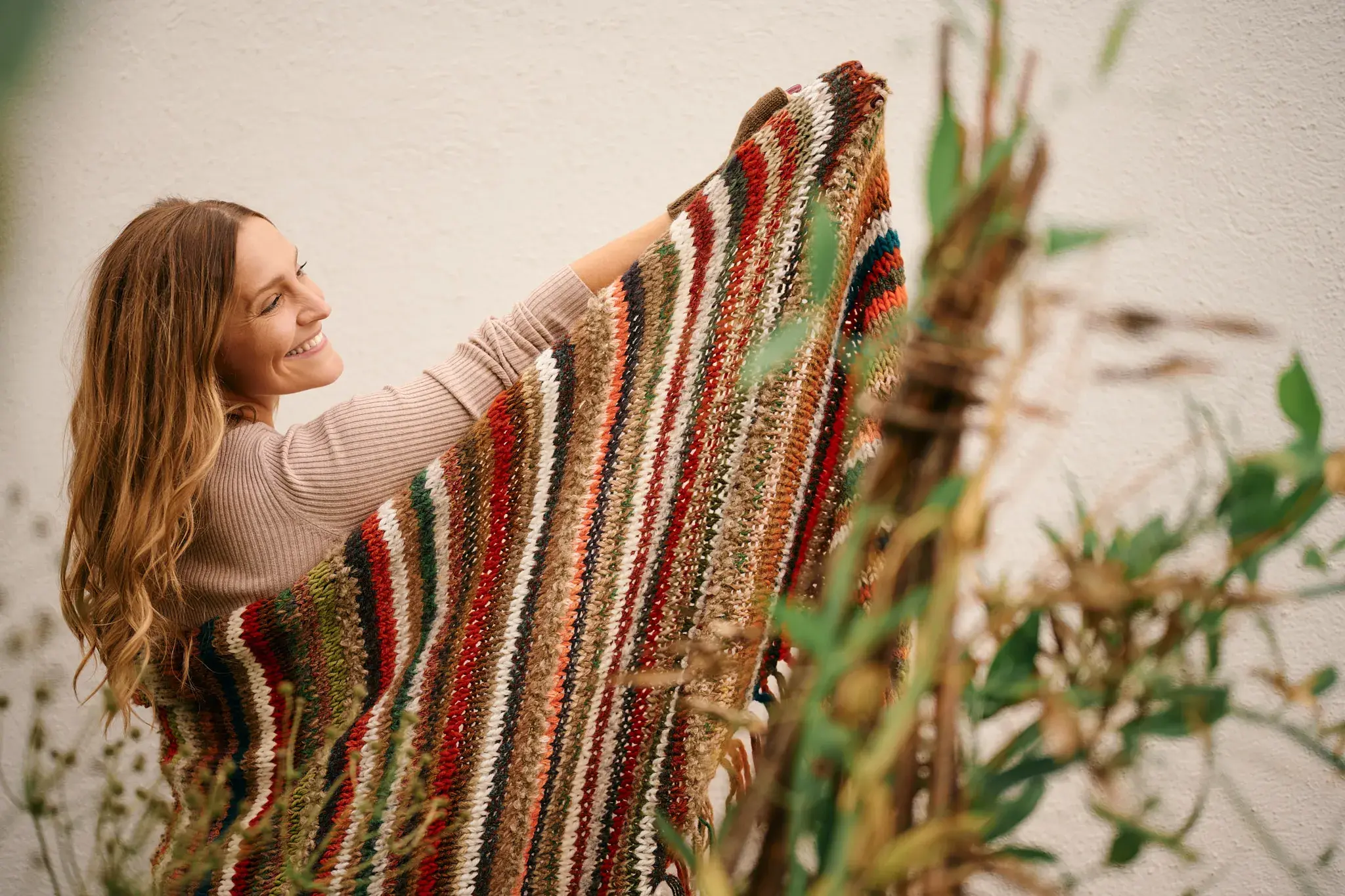 Model präsentiert eine farbenfrohe gestreifte Stola in Herbstfarben